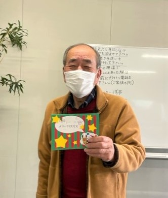 長野県　松本市　就労移行支援事業所　ブライトまつもと　クリスマスカードを手にニッコリの講師
