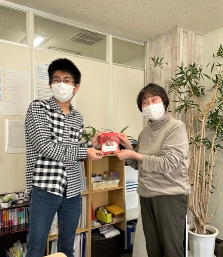 長野県　松本市　就労移行支援事業所　ブライトまつもと　クリスマスカードを手にニッコリの講師と利用者